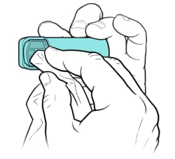 Una mano sujetando el inhalador, con la otra utilizando un paño para limpiar la boquilla.