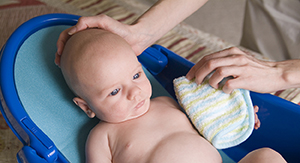 Newborn baby being bathed.