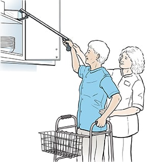 Physical therapist show someone how to use long-handled reacher tool to reach high shelf.