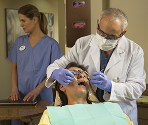 Dentist examining woman's teeth.
