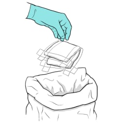 Gloved hand throwing old dressing into trash.