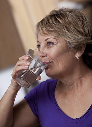 Woman drinking a glass of water.