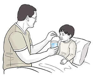 Child sitting up in bed is being given water by spoonful by man.