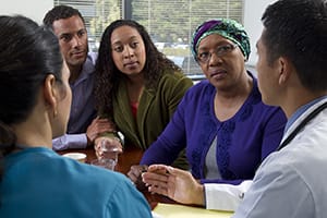 Female with family members talking to healthcare provider.